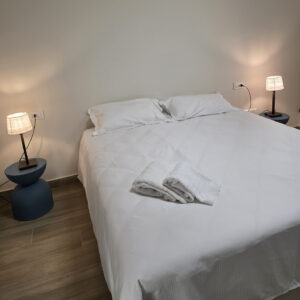 letto matrimoniale con lenzuola bianche ed asciugamani